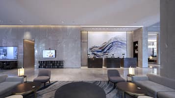 Un vestíbulo moderno con paredes de mármol, un mural abstracto de gran tamaño y un mostrador de recepción.