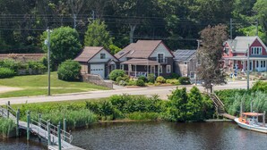 A riverside property with a dock, a wooden bridge, and houses with a red roof. - Waterfront Cottage - Mystic, Westerly, Stonington Beaches and Casinos Nearby (Stonington)