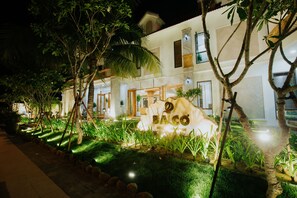 Vista frontal de la propiedad por la tarde o noche