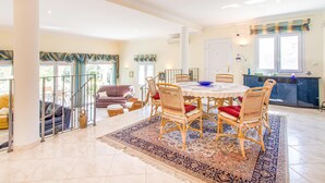 A spacious dining area with a round table, wicker chairs, and a patterned rug. - Gorgeous home in Trullent (Trullent)