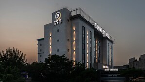 Een modern hotel met een opvallend 'B'-logo op de gevel, grote ramen en een goed verlichte ingang.