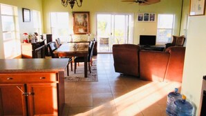 A spacious living area with a dining table, sofa, and a ceiling fan. - The perfect escape to Paradise!!This stunning 2/2 oceanfront home awaits you (Rolleville)