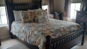 A bedroom with a bed, curtains, a nightstand, and a dresser. - The perfect escape to Paradise!!This stunning 2/2 oceanfront home awaits you (Rolleville)