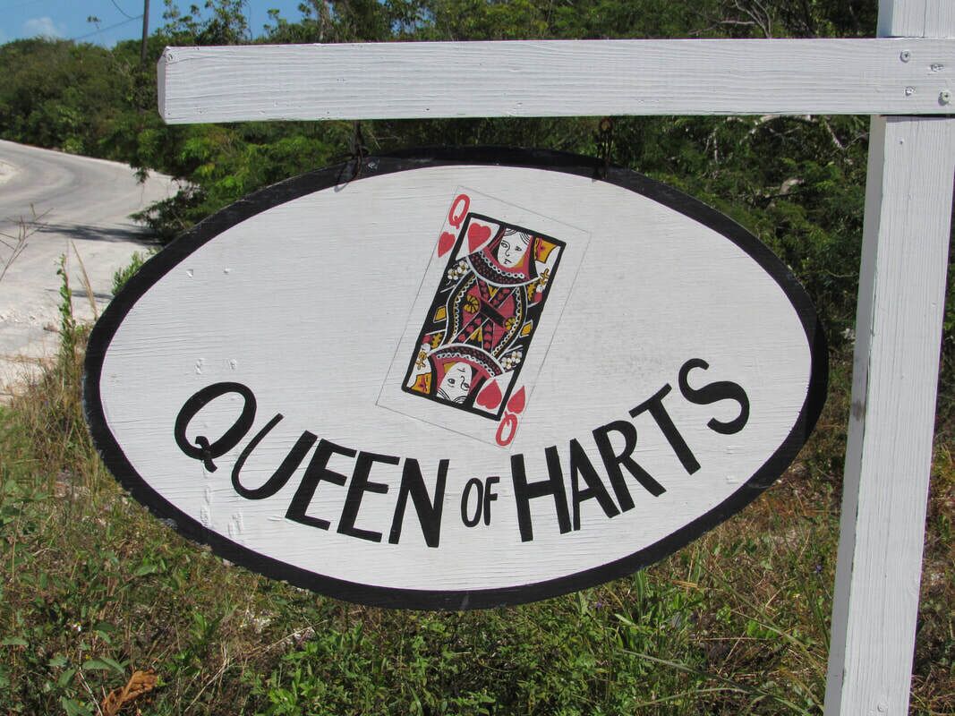 Ein Schild mit dem Text „QUEEN OF HARTS“ und einer Spielkarte.