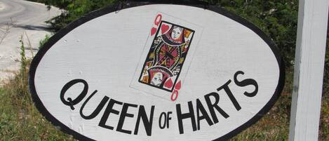 Ein Schild mit dem Text „QUEEN OF HARTS“ und einer Spielkarte.