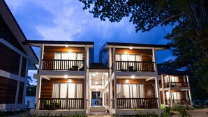 A modern two-story building with balconies, large windows, and a wooden facade. - Borneo Divers Mabul Resort (Mabul Island)