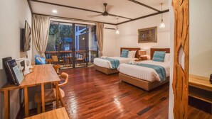 A hotel room with two beds, a wooden dining table, a ceiling fan, and a large window with curtains. - Borneo Divers Mabul Resort (Mabul Island)