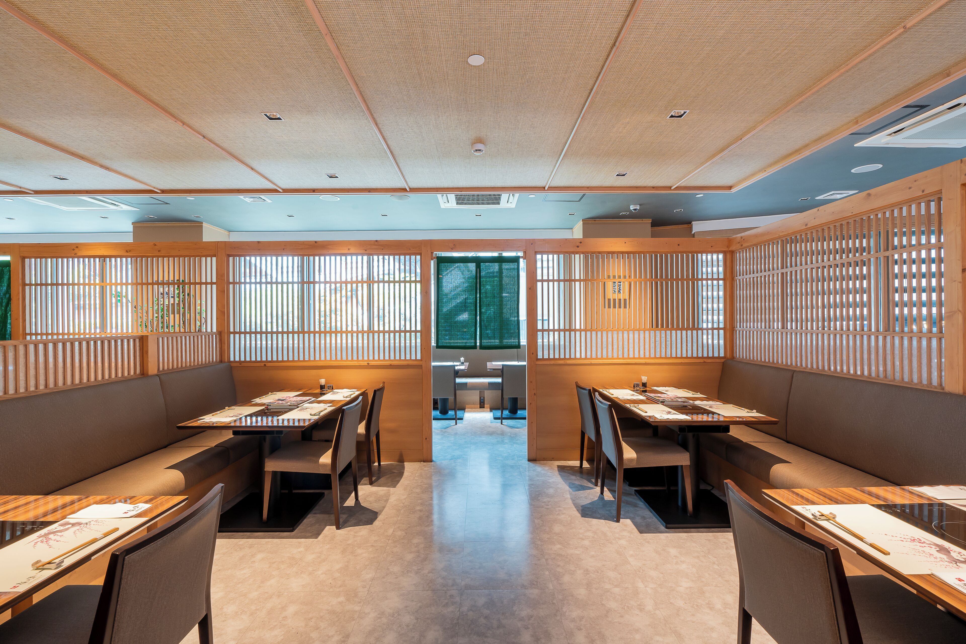 A restaurant with a traditional Japanese interior, featuring tatami mat flooring, low tables, and sliding doors.