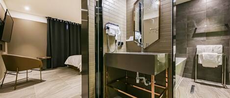 A modern bathroom with a large mirror, a sink, and a shower.