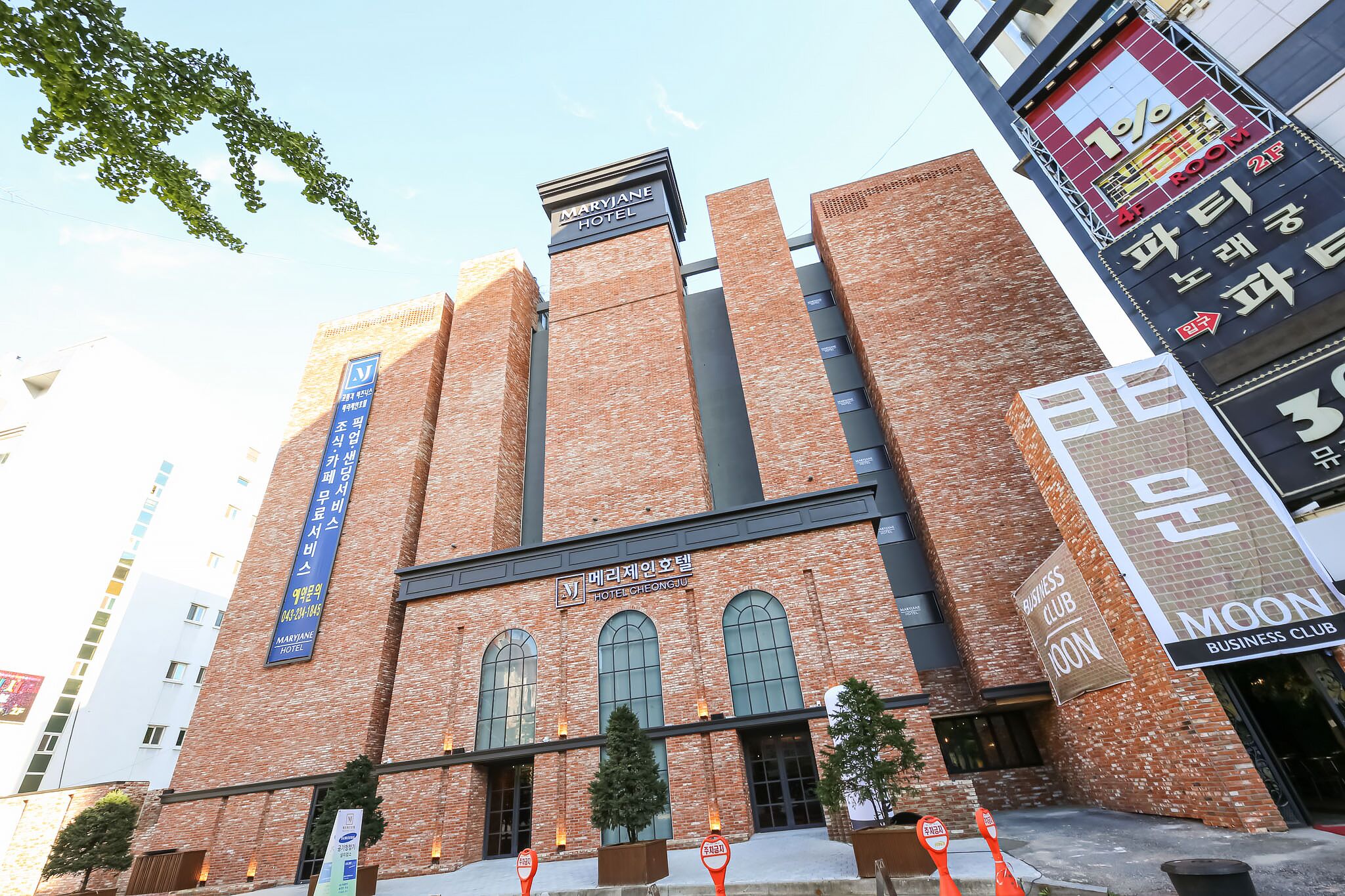 A hotel with a brick facade, large arched windows, and signage for the Marriott Hotel and a business club.
