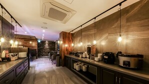 Una cocina moderna con una isla central, electrodomésticos integrados e iluminación colgante.