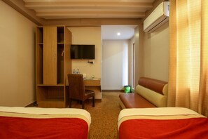 A hotel room with two beds, a desk, a chair, a TV, and an air conditioning unit. - Siddhartha Hotel Sundhara (Kathmandu)