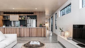 Una cocina moderna con paneles de madera, un refrigerador empotrado y una isla central.