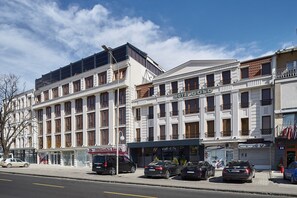 A multi-story hotel with a classic architectural style, featuring large windows and balconies. - Hotel Gold (Skopje)