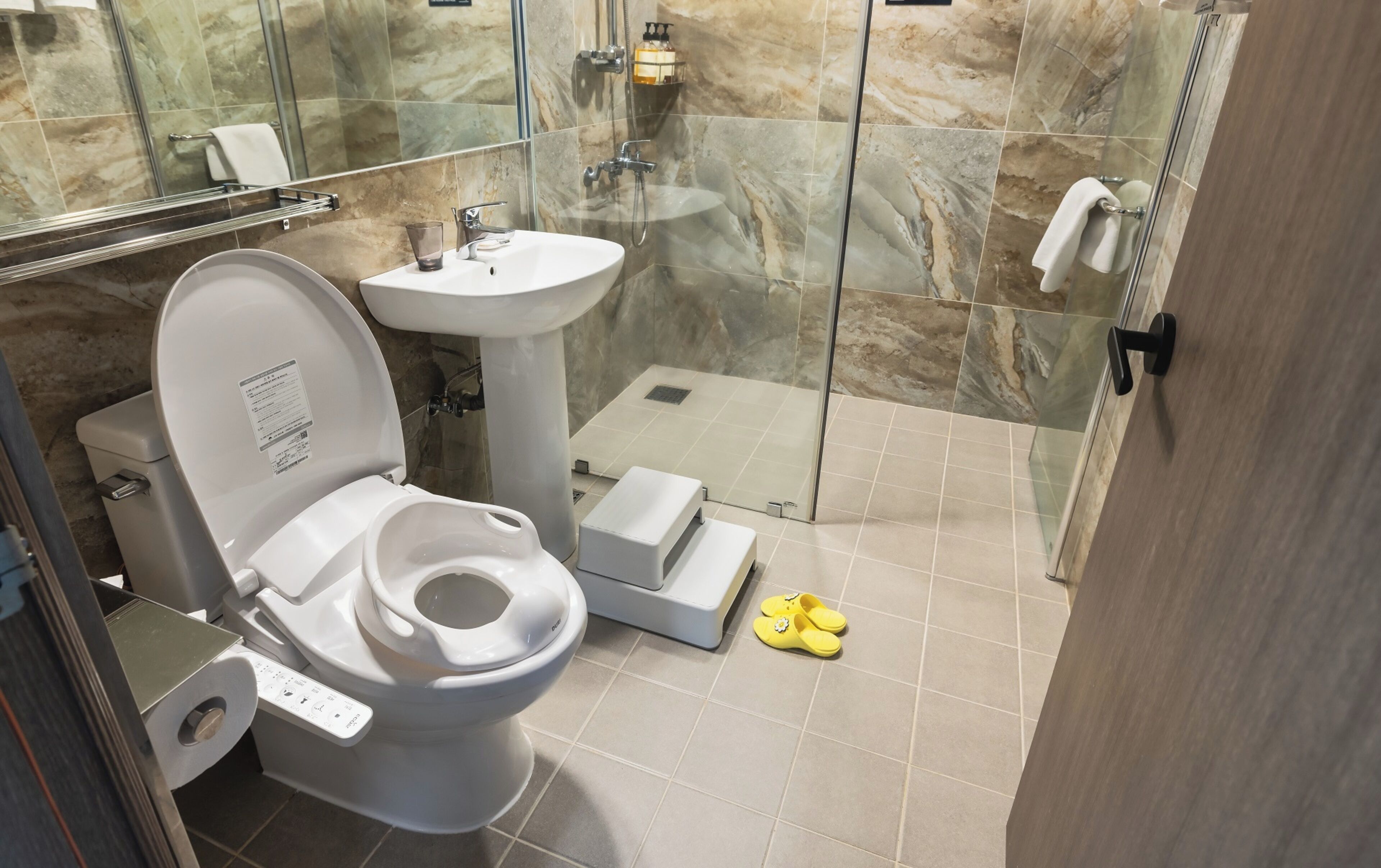 A modern bathroom with a toilet, sink, and shower area.