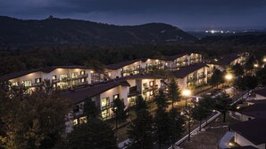 Moderni hotellikompleksi, jossa on useita rakennuksia, ja jokaisessa on parvekkeet ja suuret ikkunat.