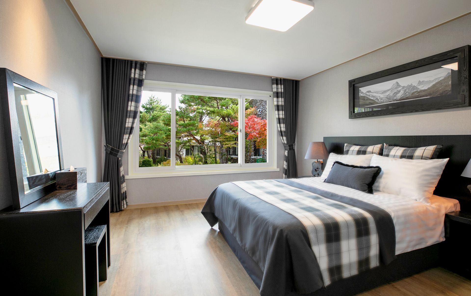 Une chambre moderne avec un grand lit, un bureau et une fenêtre avec des rideaux.