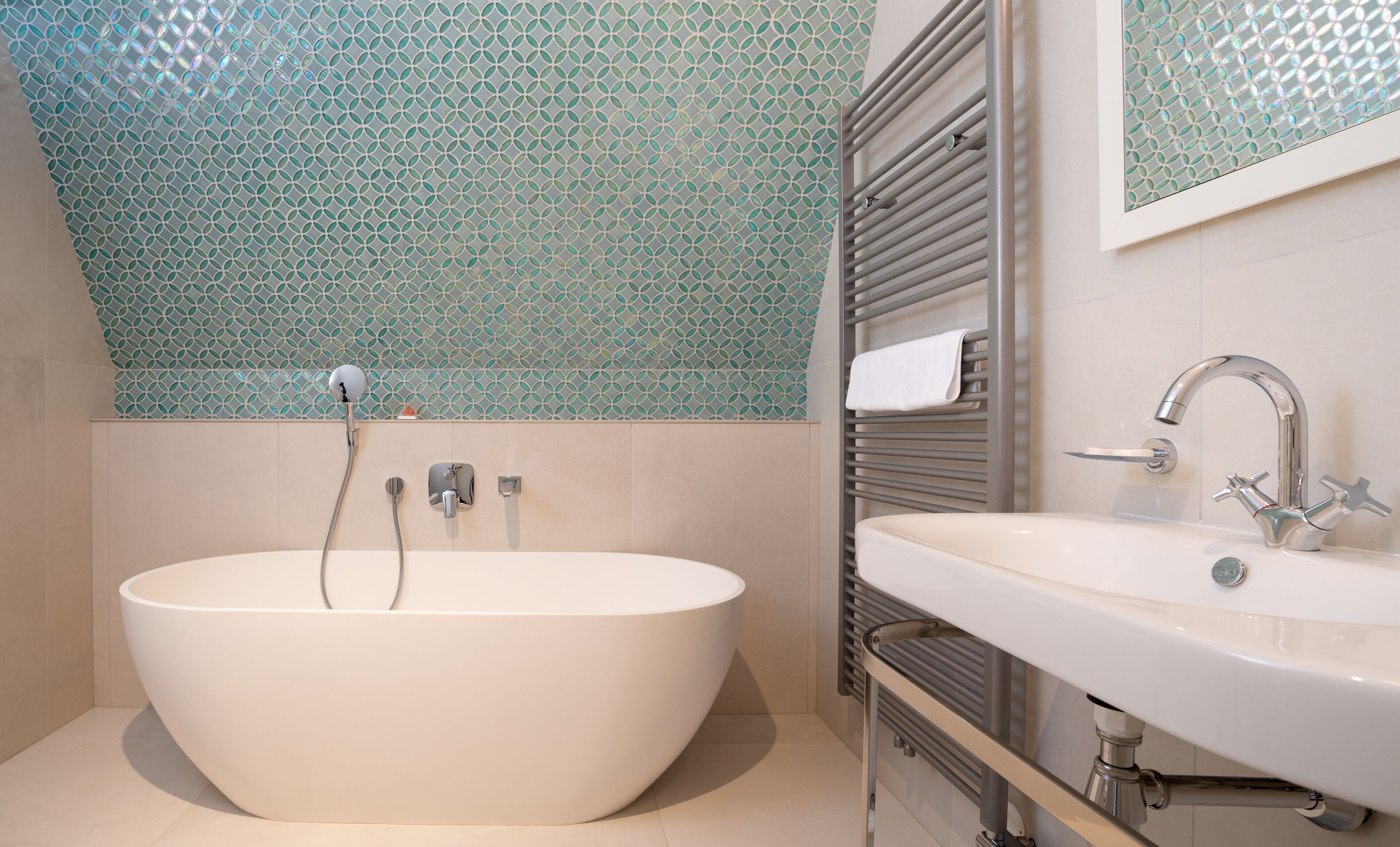 Une salle de bain moderne avec une baignoire sur pieds, un meuble-lavabo et un porte-serviettes.