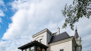 Ein großes Gebäude mit einer Terrasse, die Sitzgelegenheiten und Sonnenschirme im Freien bietet.