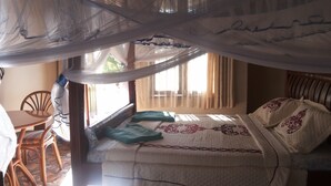 A bedroom with a bed, a chair, and a window with curtains. - Parkside Safari Lodge (Pakwach)