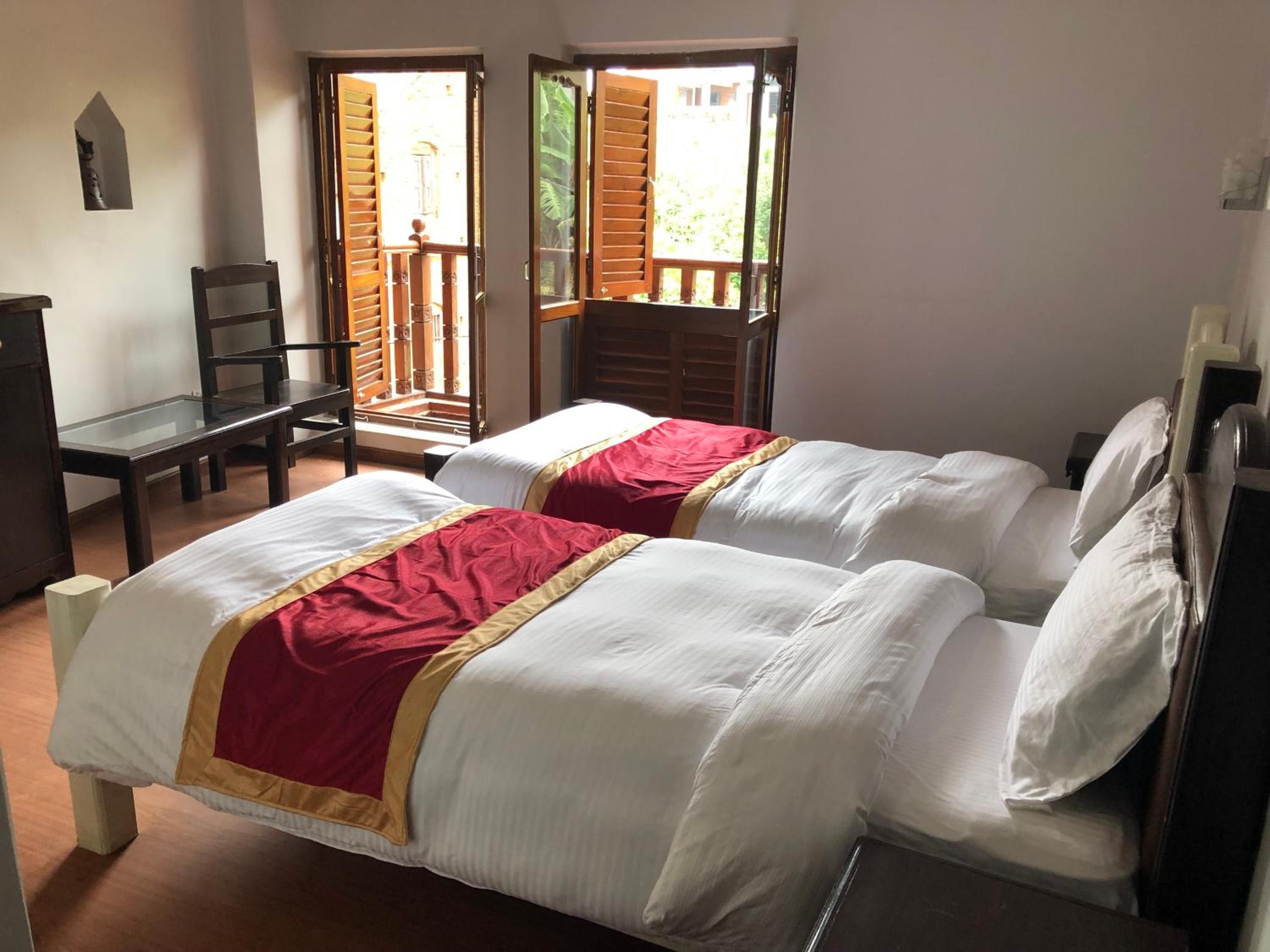 Una habitación con dos camas, un escritorio y una silla.