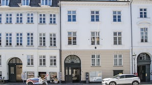A row of white buildings with multiple windows and a parked car in front. - The Churchill Penthouse by Daniel&Jacob’s (Copenhagen)