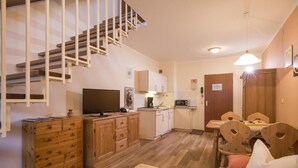 A compact living space with a kitchen, dining area, and a staircase. - Charming vacation apartment in Inntal ,with microwave,wifi,for2-4 guests,on 2 floors/15 (Oberaudorf)