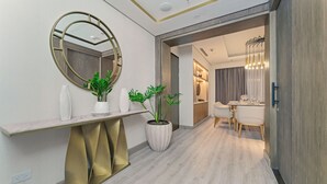 A modern interior with a marble console table, a large mirror, and potted plants.