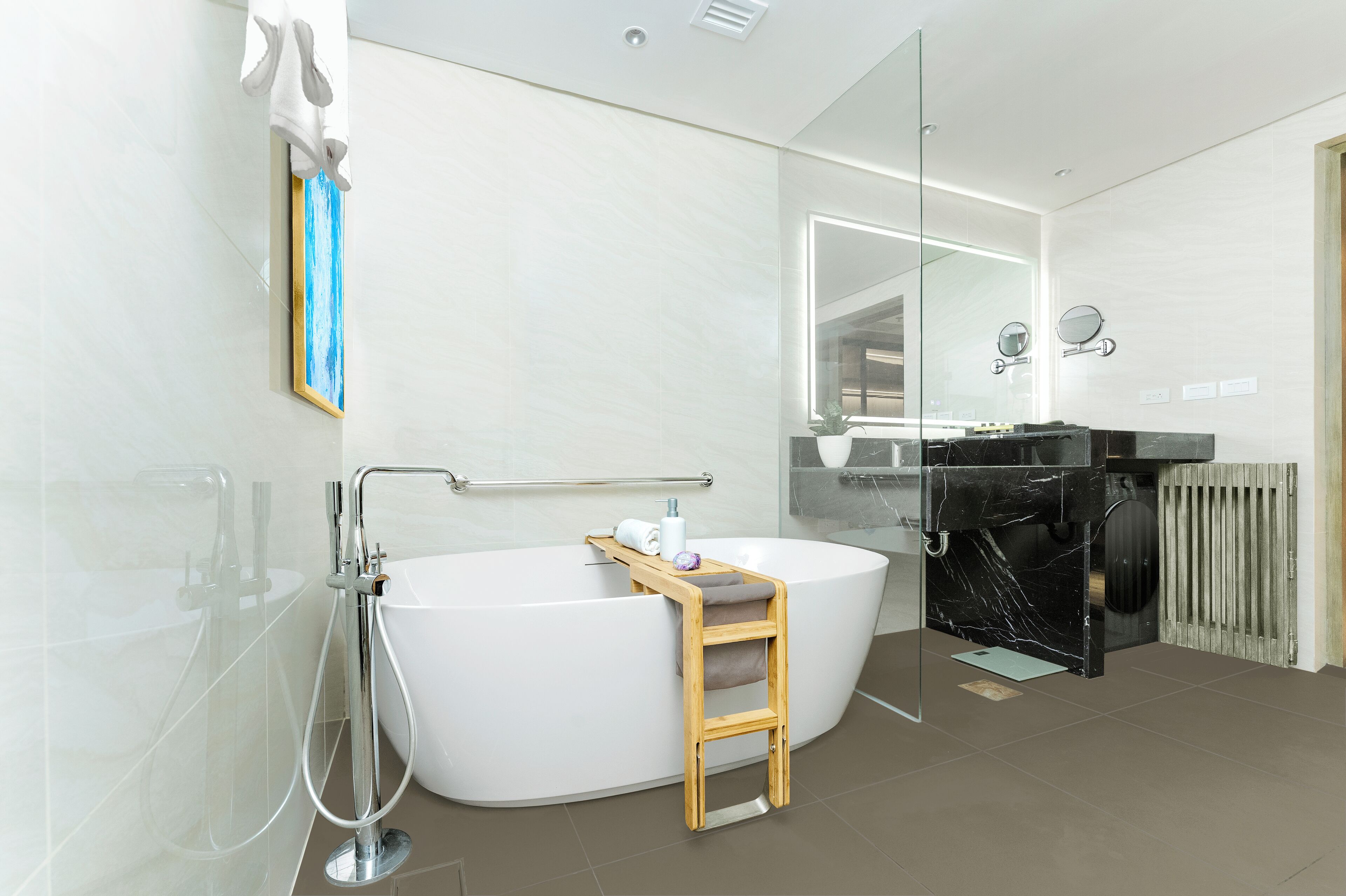 A modern bathroom with a freestanding bathtub, a wooden stool, a glass shower enclosure, and a vanity with a black marble countertop.
