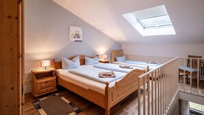 A bedroom with two beds, a skylight, a nightstand, and a wooden dresser. - Vacation apartment 2-5 persons in Oberaudorf ,sauna,playroom,fitness room/16 (Oberaudorf)