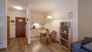 A compact living space with a kitchenette, a dining area, and a seating area with a sofa. - Vacation apartment 2-5 persons in Oberaudorf ,sauna,playroom,fitness room/16 (Oberaudorf)