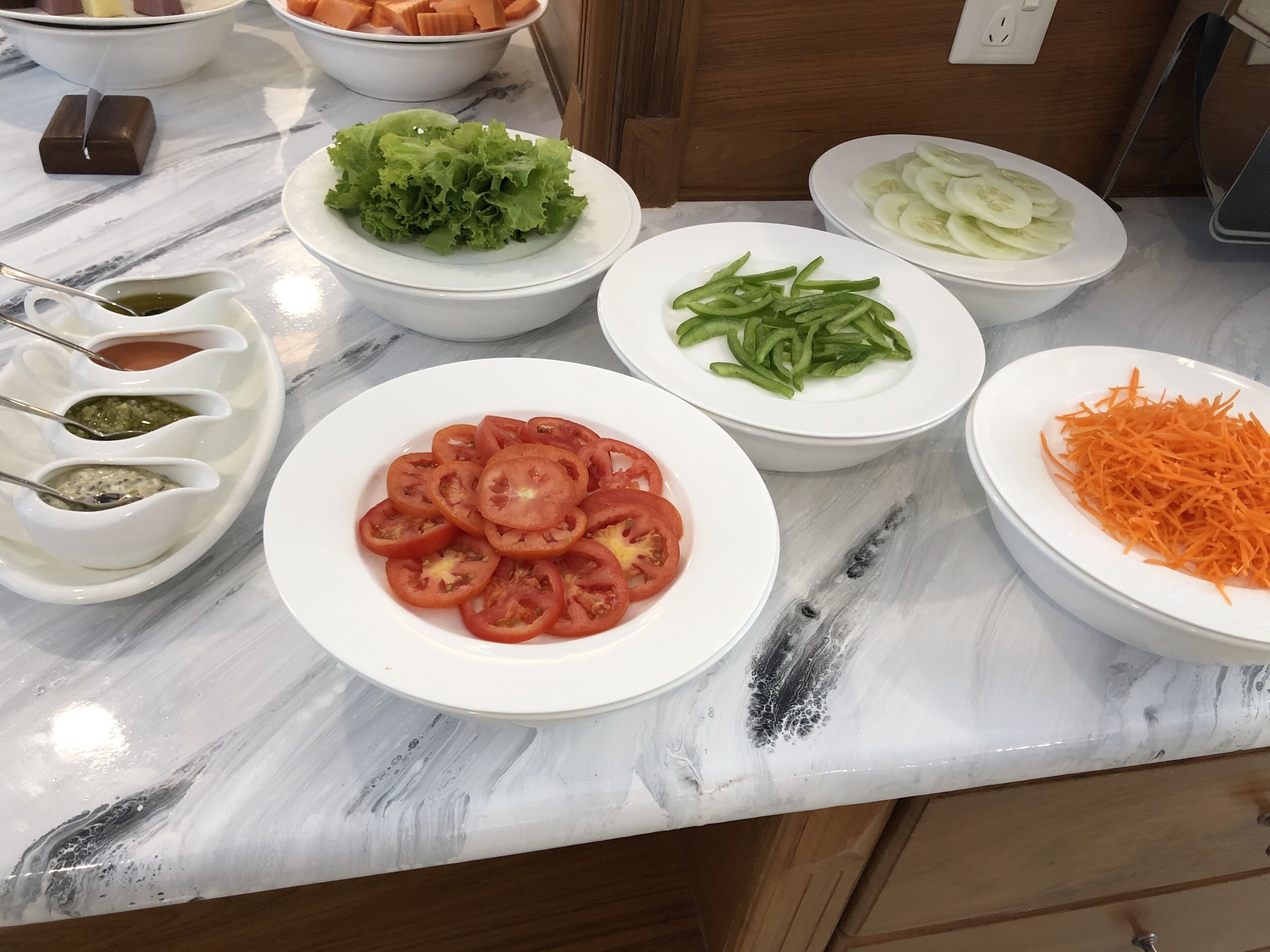 A kitchen counter with various vegetables and condiments.