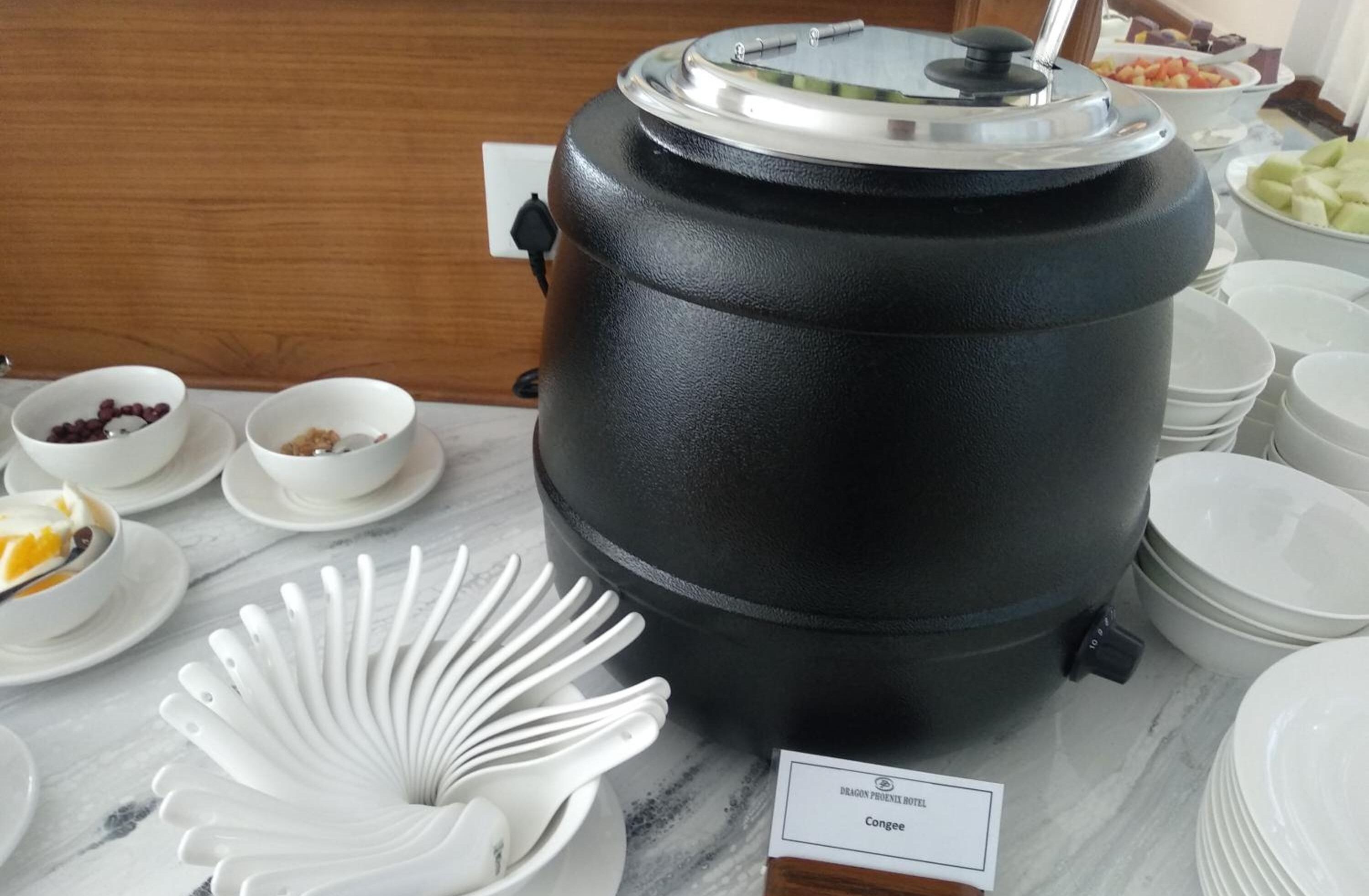 A buffet setup with a large black container labeled "Congee" and various bowls of food.