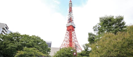 A red tower structure in a park with benches and trees.