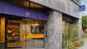 The exterior of the Mimaru Apartment Hotel in Tokyo Shinjuku West, featuring a modern design with a glass entrance and a purple awning. - MIMARU Tokyo Shinjuku West (Tokyo)