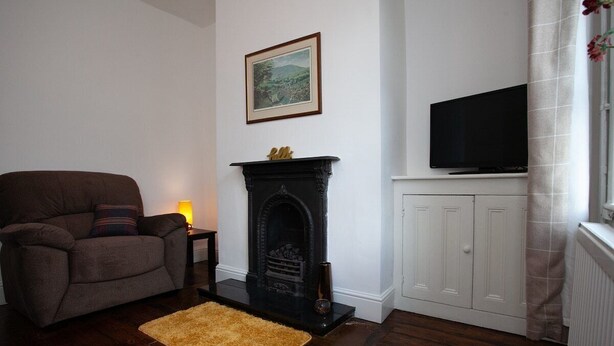 A living room with a fireplace, a television, and a sofa. - Spacious 3 bedroom Cottage in Whalley (Whalley)
