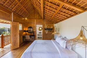 Relax in a warm and inviting bedroom with a large bed, bedside table, and desk area.