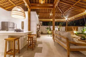 Cozy living area with a central island, cushioned bench, and dining table for two.