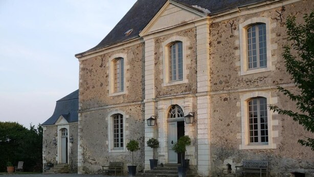 A large, historic stone building with a symmetrical facade, multiple windows, and a central entrance with steps. - Chambres d'hôtes Logis de la Juquaise (Bierné-les-Villages)
