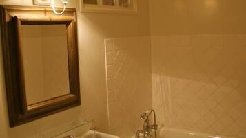 Une salle de bain avec un lavabo, un miroir et une baignoire.