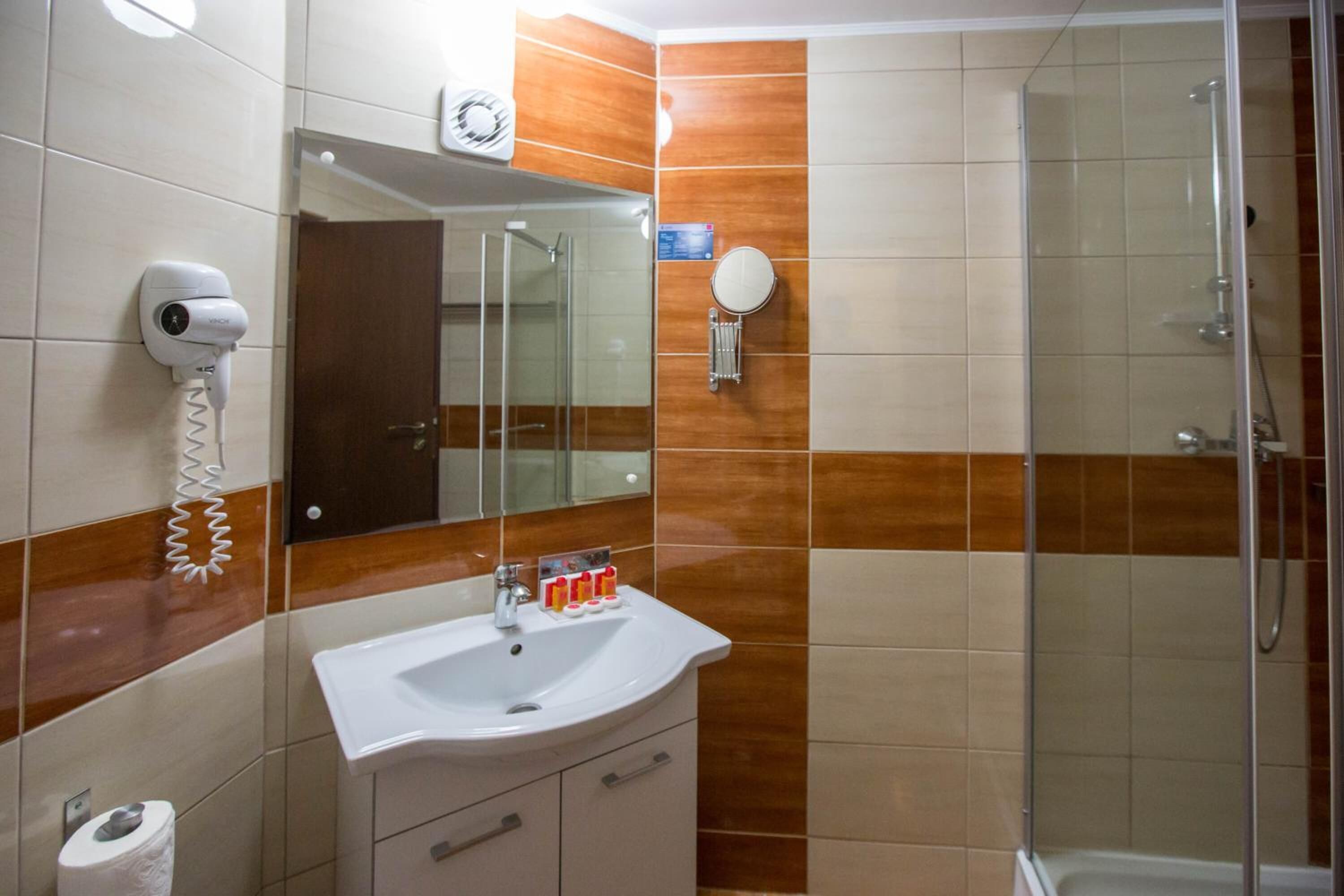 Ein Badezimmer mit Waschbecken, Spiegel und Dusche.