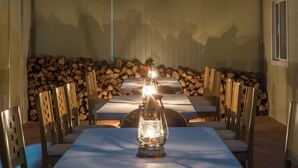 A dining area with a long table, chairs, and a lantern in the center.