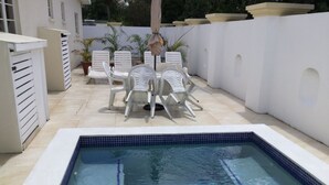 A swimming pool with white chairs and a tiled deck. - Private detached villa in a quiet location close to the sea and beaches (Porters)