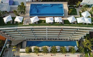 Relax by the rectangular pool surrounded by a white deck and shaded by umbrellas.