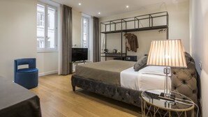 Een moderne slaapkamer met een groot bed, een nachtkastje, een televisie en een kledingkast.