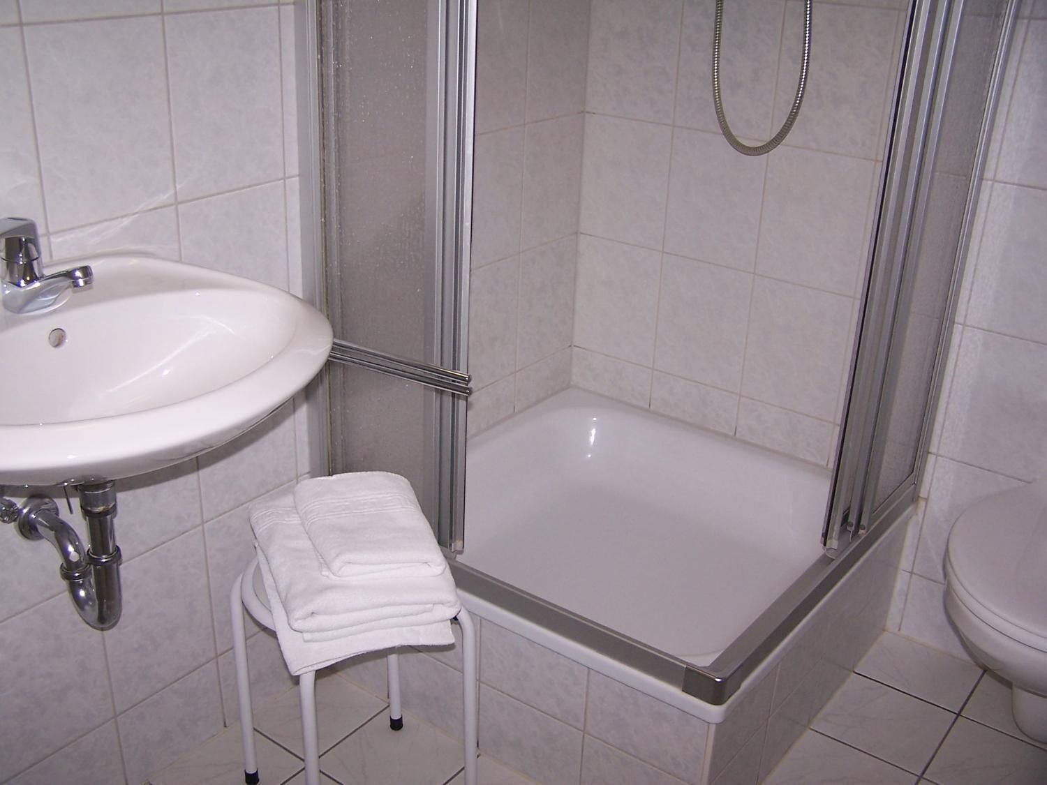 A bathroom with a sink, a shower, and a toilet.