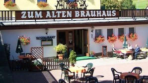 A restaurant named Zum Alten Brauhaus with outdoor seating and flower boxes on the building. - Zum Alten Brauhaus (Oberwiesenthal)