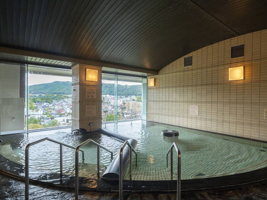 Ein Thermalbad mit Blick auf eine Stadt und Hügel.