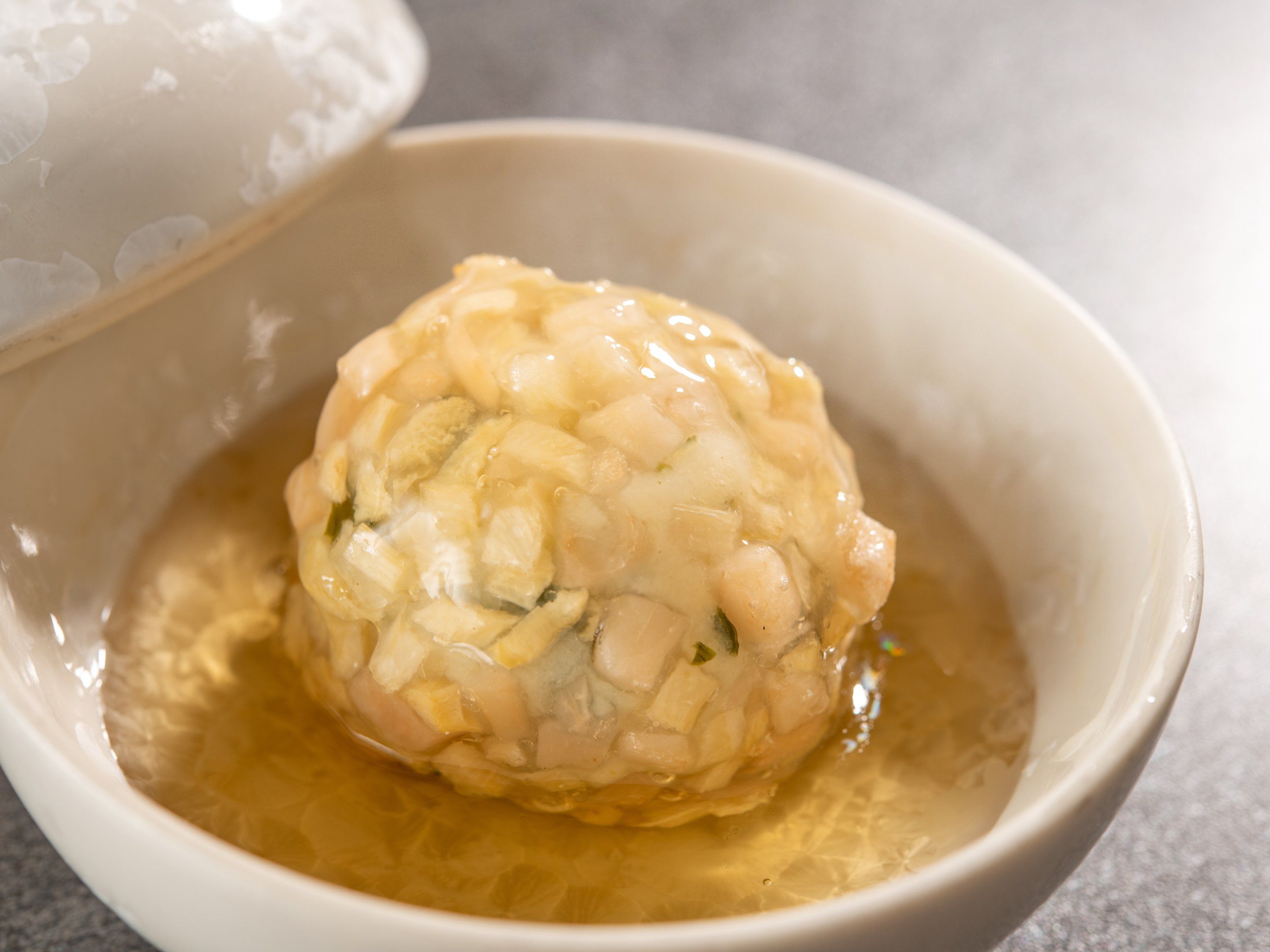 A bowl containing a food item with a liquid, possibly a soup or stew.