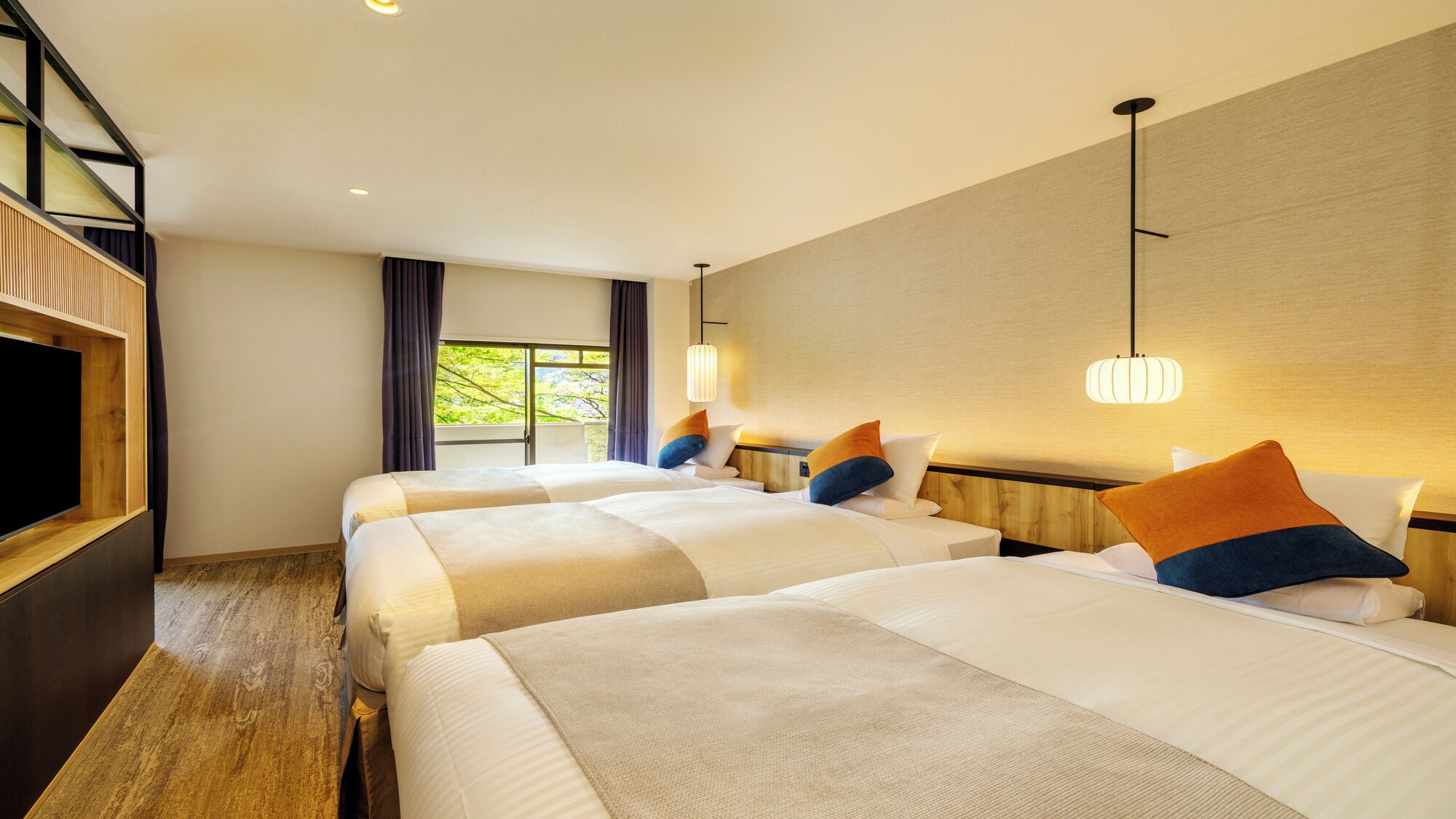 Habitación de hotel con dos camas, un televisor y un ventanal con cortinas.